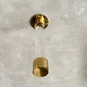 May include: A gold ceiling mount with a clear acrylic rod and a gold cap.