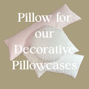 Op de afbeelding: Een wit kussen voor decoratieve kussenslopen. Het kussen is rond en heeft een roze kussensloop erop. De tekst "Pillow for our Decorative Pillowcases" staat in wit op de kussens.