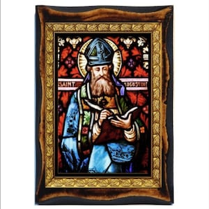 Op de afbeelding: Een gebrandschilderd beeld van Sint Augustinus in een houten lijst. De afbeelding toont Sint Augustinus met een boek en een ganzenveer in zijn hand. De lijst heeft een gouden bladrand met een bladontwerp.
