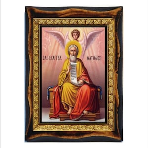Puede incluir: Un icono enmarcado de San Mateo, el apóstol y evangelista, con un marco dorado y un fondo de nubes rosas y blancas. El icono representa a San Mateo sentado en un trono, sosteniendo un rollo en su mano izquierda y una pluma en su mano derecha. El texto en el rollo está en griego y dice "OAG. EAYGTEL. MATBAIOZ" que se traduce como "Santo Evangelio de Mateo".
