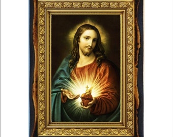 Może przedstawiać: Ramka z religijnym obrazem Jezusa Chrystusa z złotym sercem i krzyżem w środku. Obraz jest na ciemnym tle i otoczony złotą ramą z wzorem liści.