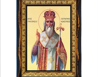 Puede incluir: Icono religioso enmarcado que representa una figura con una larga barba blanca, que lleva una corona y túnicas ornamentadas. El icono tiene detalles dorados y texto griego. El marco es oscuro con un borde interior dorado decorativo.