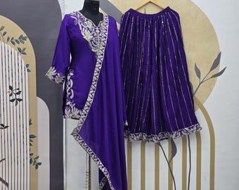May include: A purple embroidered kurta with a matching palazzo pant and dupatta. The kurta has a V-neckline and is decorated with silver embroidery. The palazzo pant has a wide leg and is also decorated with silver embroidery. The dupatta is a long, flowing scarf that is also decorated with silver embroidery.
