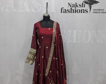 May include: A deep maroon long-sleeved dress featuring a square neckline and gold sequin embroidery on the cuffs and hem. The dress includes a matching maroon dupatta with gold trim and small floral accents, displayed on a black mannequin.