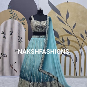 Op de afbeelding: Een lichtblauwe en turquoise lehenga met zilveren pailletten en een bijpassend topje. De outfit is op een mannequin en heeft een doorschijnende dupatta.