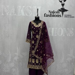 May include: A deep purple three-piece outfit consisting of a long-sleeved tunic, wide-leg trousers, and a sheer dupatta. The tunic and trousers feature intricate gold embroidery and sequin detailing along the neckline, hem, and sleeves.