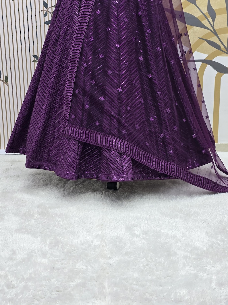 Puede incluir: Una falda de lentejuelas morada con una superposici&oacute;n transparente a juego. La falda tiene un patr&oacute;n de chevron y un borde decorativo.