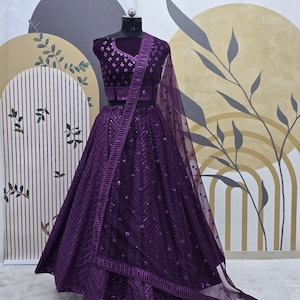 Puede incluir: Un lehenga bordado de color morado con un choli a juego. La falda est&aacute; hecha de una tela transparente con lentejuelas y un dupatta de red.