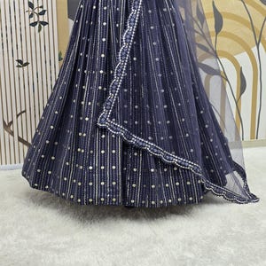 May include: A navy blue skirt and matching sheer shawl with white and gold dot and stripe pattern. The skirt has a full, flowing shape. The shawl has a scalloped edge with white beading. The outfit is displayed on a mannequin.