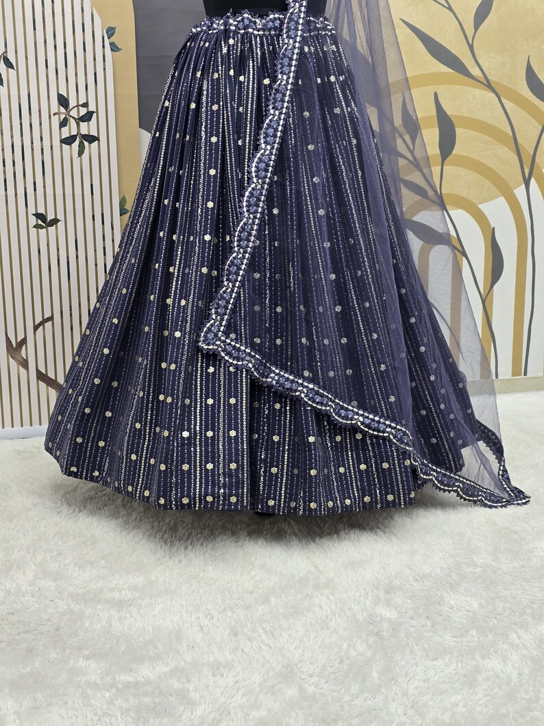 May include: A navy blue skirt and matching sheer shawl with white and gold dot and stripe pattern. The skirt has a full, flowing shape. The shawl has a scalloped edge with white beading. The outfit is displayed on a mannequin.
