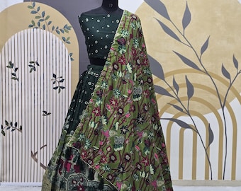 Puede incluir: Un lehenga bordado en verde y dorado con un dupatta a juego en verde y dorado. El lehenga tiene un patrón floral y el dupatta tiene un patrón de paisley.