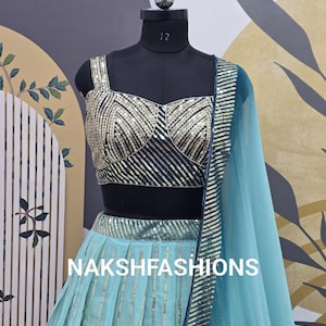 Op de afbeelding: Een turquoise blauwe en zwarte crop top en rok set met gouden pailletten. De top heeft een sweetheart halslijn en de rok is A-lijn. De set is op een mannequin en de tekst "NAKSHFASHIONS" is zichtbaar.