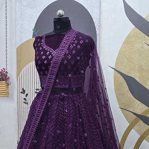 Puede incluir: Un lehenga bordado de color morado con un choli a juego. El lehenga est&aacute; hecho de tela de red con lentejuelas y un patr&oacute;n de chevron. El choli tiene un escote en V profundo y es sin mangas.