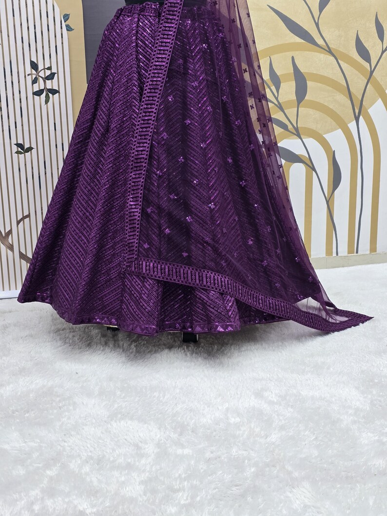Puede incluir: Una falda de lentejuelas morada con una superposici&oacute;n transparente a juego. La falda tiene un patr&oacute;n de chevron y est&aacute; decorada con peque&ntilde;as lentejuelas.