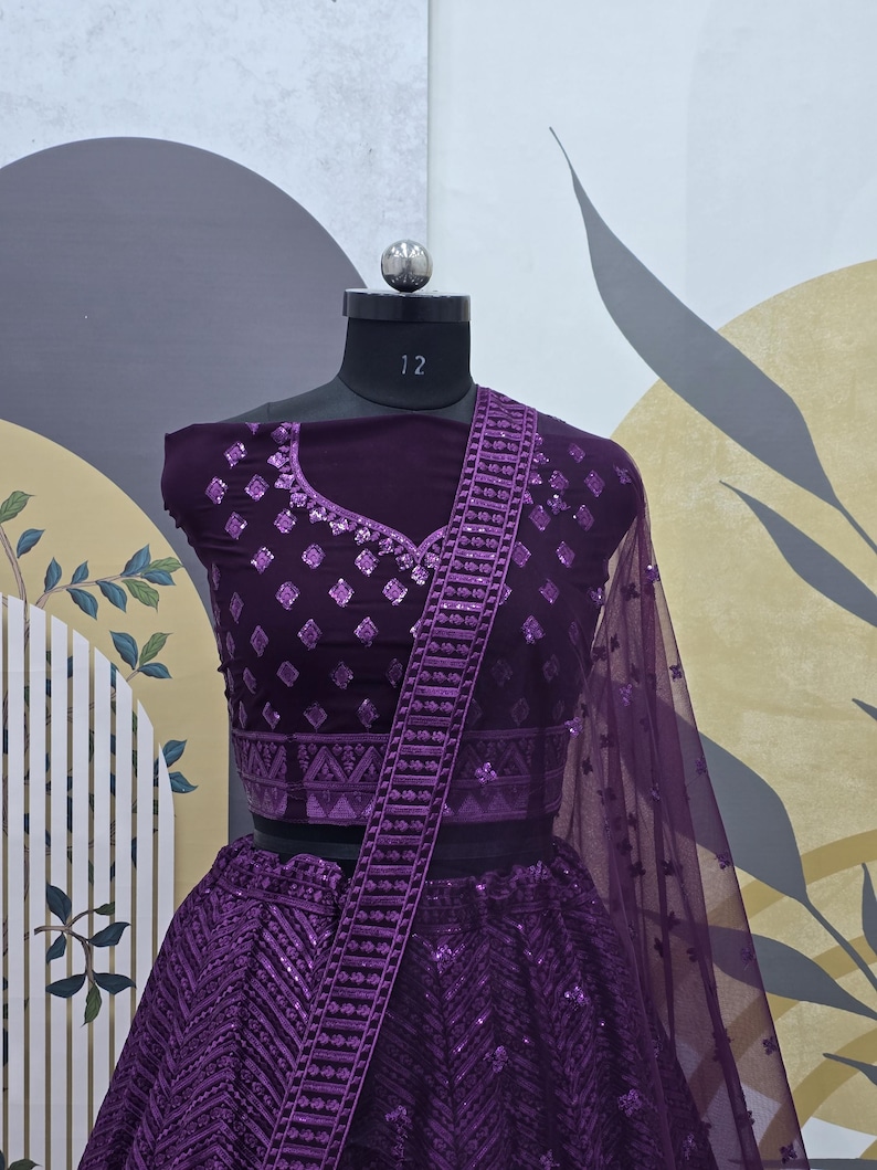 Puede incluir: Un lehenga bordado de color morado con un choli y un dupatta a juego. El lehenga presenta un patr&oacute;n geom&eacute;trico y lentejuelas. El choli tiene un escote en V y tambi&eacute;n est&aacute; adornado con lentejuelas.