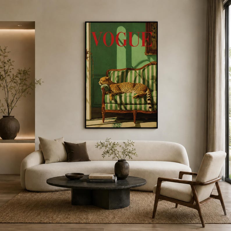 a living room with a large framed poster of a cheetah on the wall, a white sofa, a round coffee table, and a wooden chair.