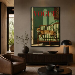 a living room with a large framed poster of a cheetah resting on a striped sofa, a wooden coffee table, and a leather armchair.