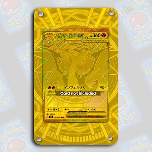 May include: A rectangular gold-colored metal display frame featuring a central cutout designed to hold a trading card. The frame has a metallic finish with a circular pattern and four small silver-colored rivets at each corner. The text Card not included is printed in white across the center of the frame.