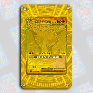 May include: A gold-colored card holder with a gold-colored card inside. The card features Japanese text and a holographic design. The text "Card not included" is visible. The holder has four corner holes.