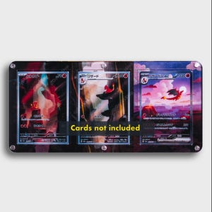 May include: A rectangular black acrylic display frame with three vertical slots designed for trading cards. The frame features silver hardware at the corners and edges, and a central yellow text overlay that reads Cards not included.
