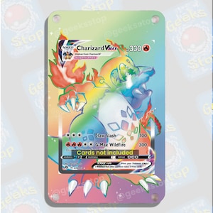 Puede incluir: Una carta de comercio de Pokemon con Charizard VMAX, una criatura naranja y amarilla ardiente con acentos azules. La carta tiene un fondo de arcoíris y el texto "VMAX Charizard VMAX HP 330" en la parte superior. La carta también incluye el texto "Claw Slash 100" y "G-Max Wildfire 300".