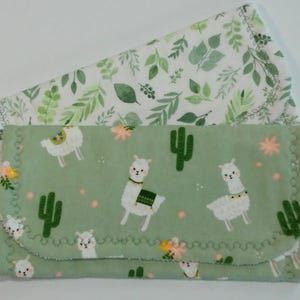 May include: Two green and white fabric burp cloths with a cactus and llama pattern. The top cloth has a white background with green leaves and the bottom cloth has a green background with white llamas and cacti.
