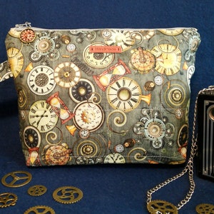 May include: A gray zippered pouch with a repeating pattern of antique clocks and gears. The pouch is decorated with the word "Handmade".