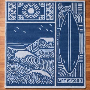 Puede incluir: Manta de ganchillo azul y blanca con un diseño costero. La manta presenta un sol, pájaros, montañas, olas y una tabla de surf. Las palabras "LIFE IS GOOD" están en la parte inferior de la manta.