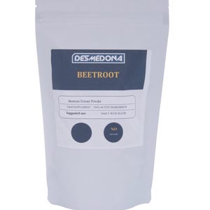 May include: A white pouch of beetroot extract powder. The label reads "DESMEDONA BEETROOT" with details about the product, including "100% ACTIVE INGREDIENTS" and "DAILY WITH WATER" as the suggested use. The pouch is sealed.