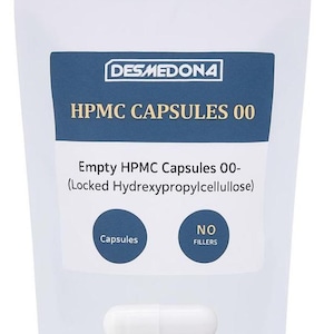 May include: A white pouch with a blue label displaying "DESMEDONA" and "HPMC CAPSULES 00." The label also states "Empty HPMC Capsules 00-" and "NO FILLERS." A white capsule is visible. The product is for capsules.