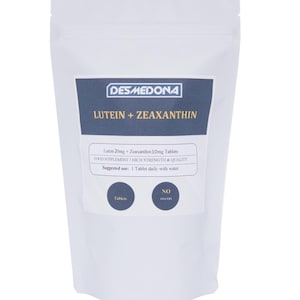 May include: A white ceramic mug with a black handle and the text "But First, Coffee" in a bold, black font. The mug is set against a blurred background, suggesting a cozy setting.