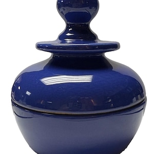 May include: A blue ceramic jar with a lid. The jar has a round body and a knob on the lid.