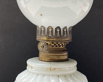 Può includere: Lampada a olio in vetro bianco con base in metallo dorato e globo in vetro bianco con un motivo a foglie dorate.