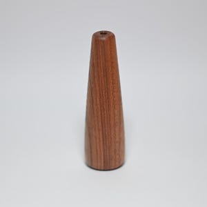May include: A wooden, brown, tapered bottle stopper.