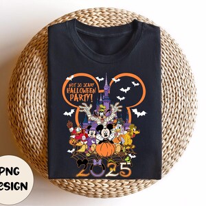 Op de afbeelding: Zwart T-shirt met een Halloween-ontwerp met Disney-personages. Het ontwerp bevat de tekst "NOT SO SCARY HALLOWEEN PARTY!" en het jaar "2025". De afbeelding toont Mickey Mouse, Donald Duck, Goofy en andere personages.