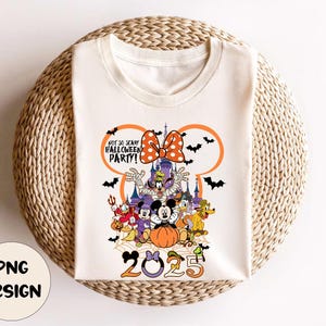 Op de afbeelding: Cr&egrave;mekleurig T-shirt met een Halloween-ontwerp met Disney-personages. Het ontwerp bevat Mickey en Minnie Mouse, Donald Duck, Goofy en Pluto, samen met een pompoen en vleermuizen. De tekst luidt "Not So Scary Halloween Party!" en "2023".