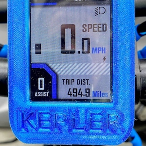 May include: A blue and black electric bike display with a digital screen showing a speed of 0.0 mph, a battery level of 100%, and a trip distance of 494.9 miles. The display also shows an assist level of 0. The display is labeled "KERLER".