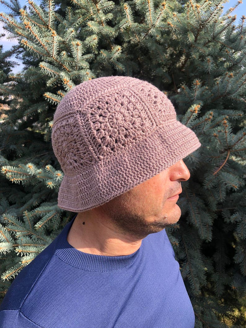 May include: A crocheted bucket hat in a light brown color. The hat has a wide brim and a textured design.
