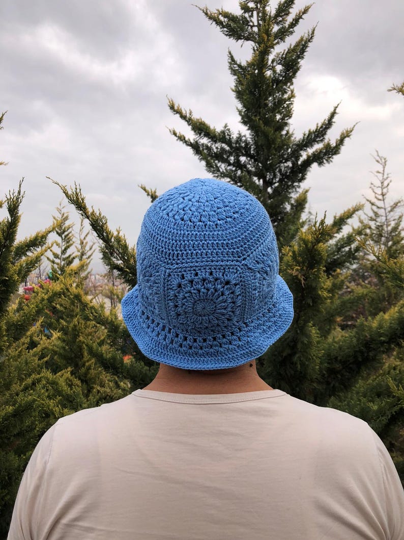 May include: A light blue crocheted bucket hat with a floral design.