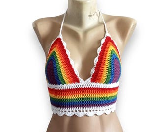 Puede incluir: Un top halter de crochet arcoíris con un ribete de crochet blanco. El top está hecho con una variedad de colores, incluyendo rojo, naranja, amarillo, verde, azul, índigo y violeta.