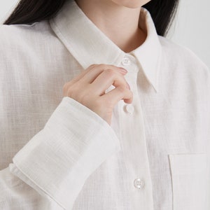 A woman is wearing a Women White Linen Oversized Shirt.