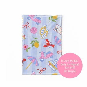 Pu&ograve; includere: Un asciugamano a righe blu e bianche con un motivo ripetuto di scooter rosa, conchiglie, infradito, limoni e fiocchi rossi. Altri elementi includono un fiore rosa, un'aragosta rossa e un ombrello rosa e blu. L'asciugamano ha un bordo bianco.