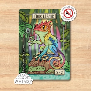 Può includere: Una carta fantasy art colorata con una lucertola-rana. La carta ha un bordo verde con la scritta "FROG LIZARD" in alto. La lucertola è raffigurata in colori vivaci, con un motivo arcobaleno sul corpo. La carta include anche il testo "TOKEN CREATURE - FROG LIZARD" e "3/3".