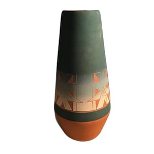 May include: A tapered vase with a matte dark green upper section and a terracotta base. The middle features a band with etched geometric star patterns in a light gray and orange gradient, contrasting against the dark green and terracotta surfaces.