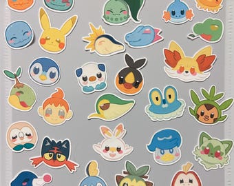 May include: A collection of colorful cartoon character stickers featuring various Pokemon characters. The stickers are on a white background with a grid pattern.
