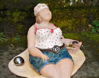 Scultura in ceramica "Donna grassa seduta sulla sabbia con palla di bronzo e cesto da picnic", effetto arenaria fine, parte superiore a pois bianchi e rossi,