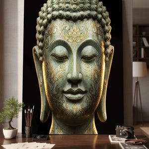 Puede incluir: Una serena escultura de cabeza de Buda con intrincados patrones florales dorados sobre una superficie verde-azulada. La obra de arte se exhibe sobre un fondo negro, creando un contraste llamativo. La imagen es un primer plano del rostro de Buda.