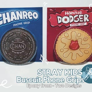 May include: Two phone grips designed to look like biscuits. One is a chocolate biscuit with the word "CHAN" in white lettering. The other is a biscuit with a red jelly centre and the words "Hannie Dodger" in red lettering.