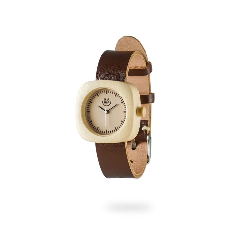 May include: A square-faced wristwatch with a light wood grain case and a tan face. The watch has a dark brown leather band. The watch face has black minute markers and the brand name "KA MA" printed on the face.
