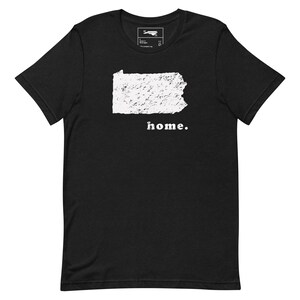 Puede incluir: Camiseta negra con un contorno blanco del estado de Pensilvania y la palabra "home." impresa debajo.